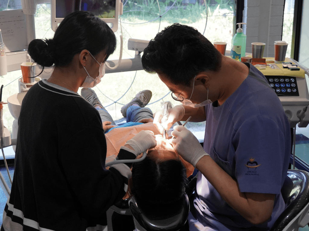 A child receiving dental care from two Korean dentists