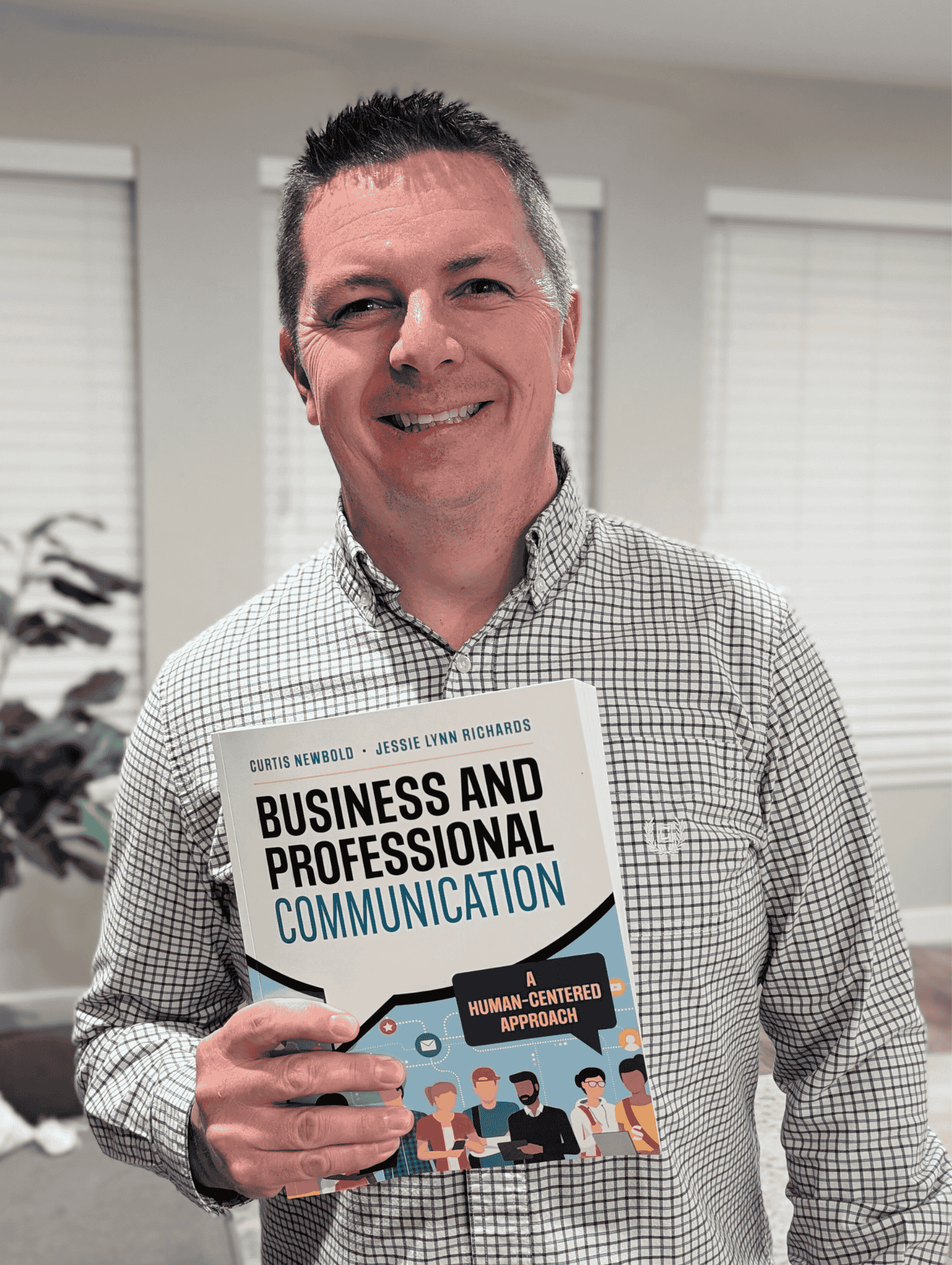 Man smiling and holding up new textbook